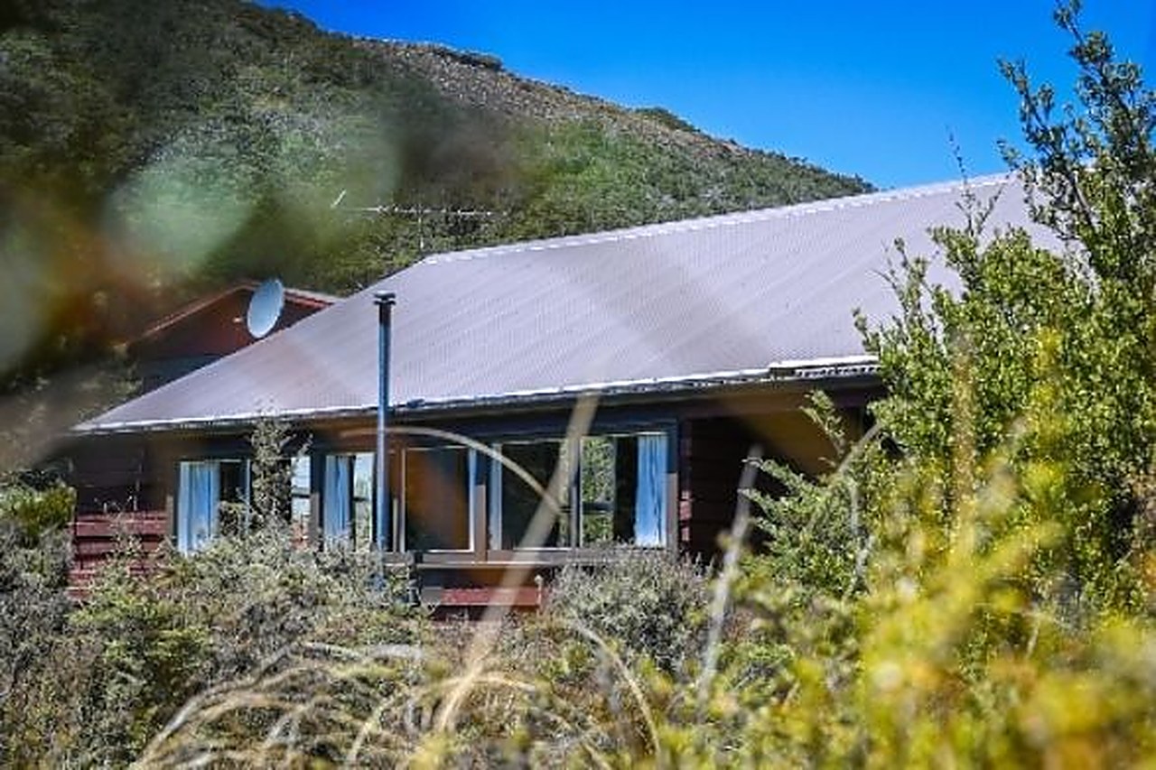 The Chalet, a single-storey lodge among tussock and shrubs at Whakapapa Village